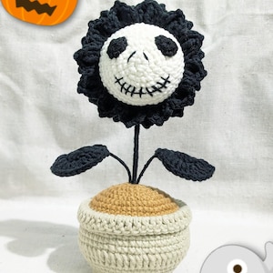 May include: A handcrafted crochet flower featuring a Jack Skellington face, black petals, and leaves. The flower is planted in a beige pot with brown 'soil', ideal for Halloween decorations. A unique, handmade item.