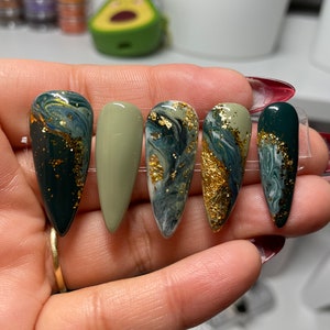Green and gold press on nails with marble designs.