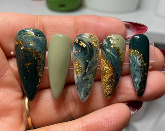 Green and gold press on nails with marble designs.