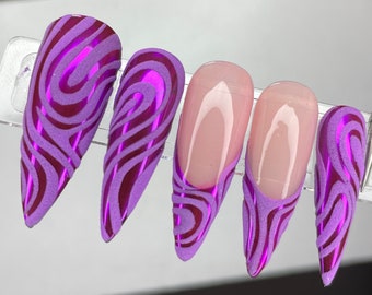 May include: Five long, almond-shaped artificial nails. Two nails feature a purple and burgundy swirl design. Two nails have a French tip design with a purple swirl. The fifth nail has a purple swirl design.