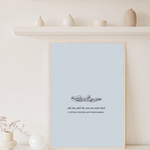 May include: A framed print with a light blue background and a black and white illustration of waves. The text reads "salt air, and the rust on your door I NEVER NEEDED ANYTHING MORE."