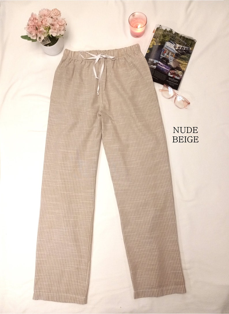 May include: Beige striped pants with a white drawstring waist.