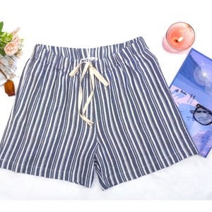 May include: Blue and white striped linen shorts with a drawstring waist.