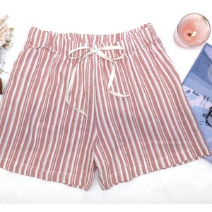 May include: Pink and white striped pajama shorts with a white drawstring tie.