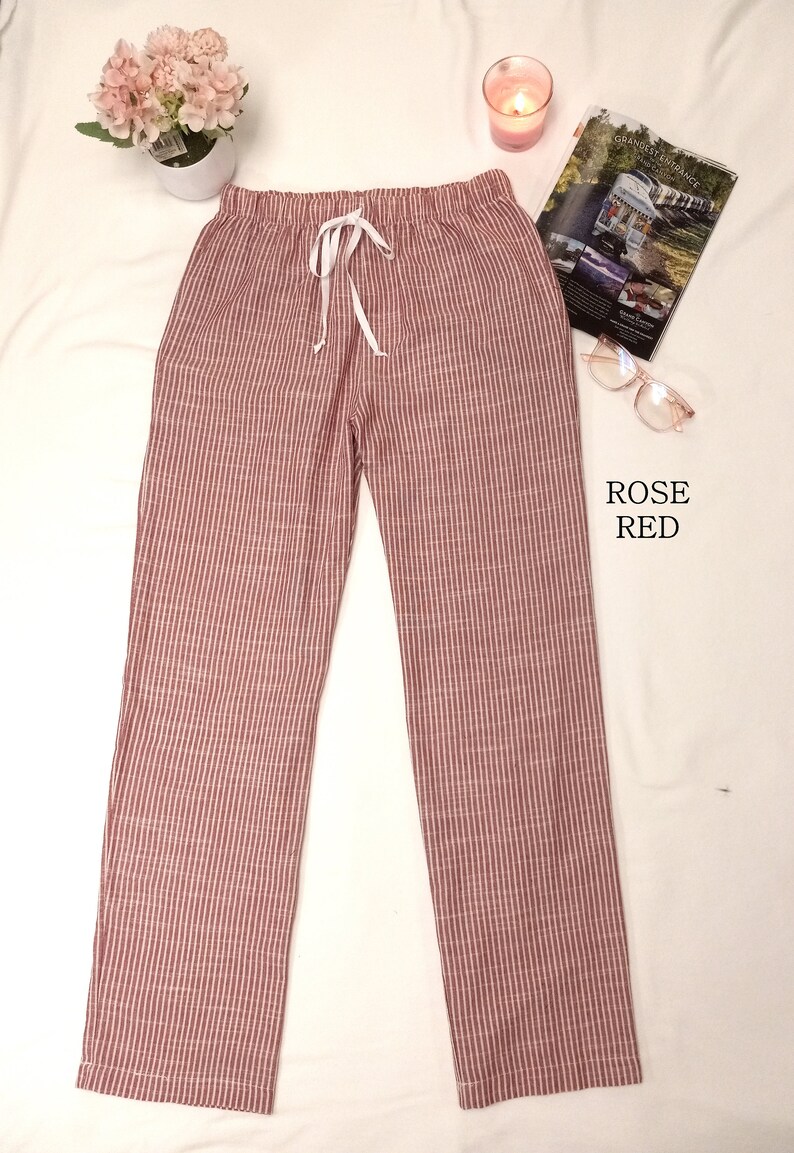 May include: Rose red striped pants with a white drawstring. The pants are made of a soft, comfortable fabric and have a relaxed fit.