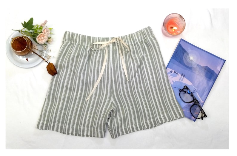 May include: Gray and white striped linen shorts with a white drawstring tie.