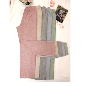 May include: A stack of striped pants in various colors, including red, beige, black, blue, and green. The pants are made of a soft, comfortable fabric and have a relaxed fit.