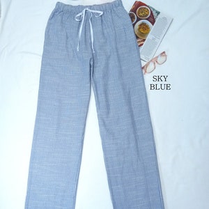 May include: A pair of light blue striped pants with a white drawstring. The pants are made of a soft, comfortable fabric and have a relaxed fit.