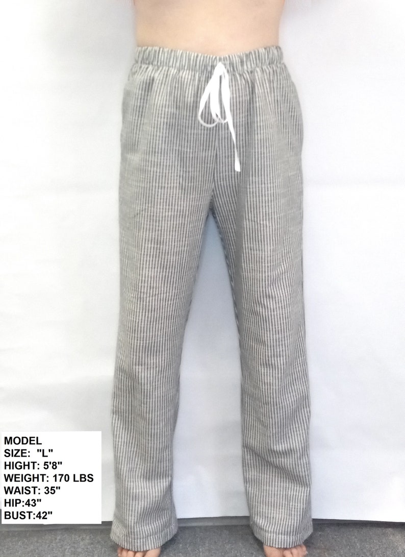 May include: A pair of gray and white striped pants with a drawstring waist. The pants are made of a lightweight fabric and have a relaxed fit.