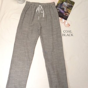 May include: Gray and white striped pants with a drawstring waist. The pants are made of a soft, comfortable fabric and have a relaxed fit.