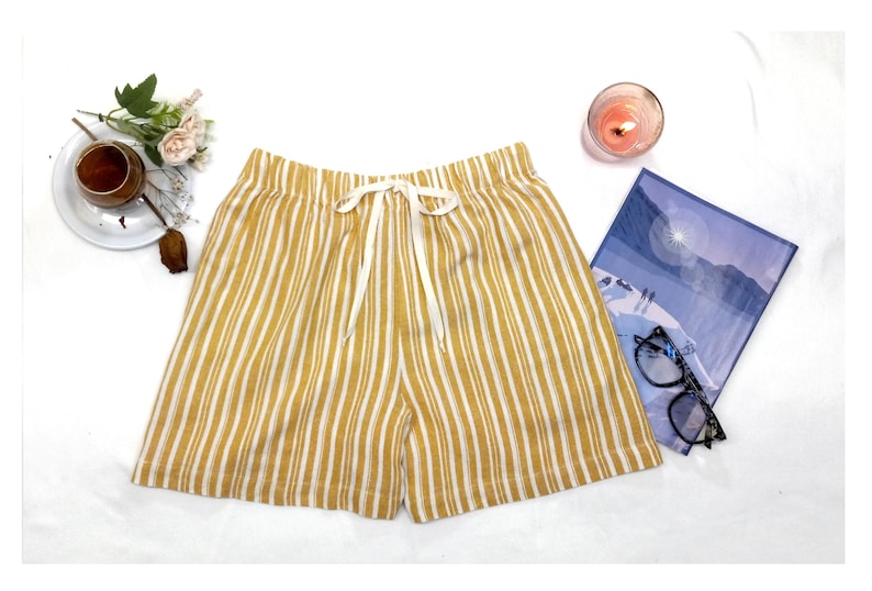 May include: Yellow and white striped linen shorts with a white drawstring tie.