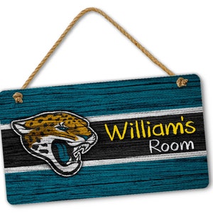 May include: A teal blue wooden sign with a white and black stripe and a Jacksonville Jaguars logo. The sign says "William's Room" in yellow text.