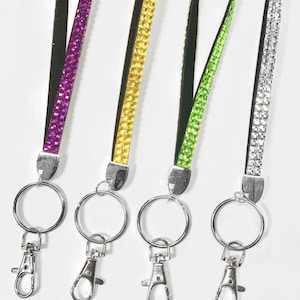May include: Four keychains with different colored rhinestone straps and silver key rings and clips.
