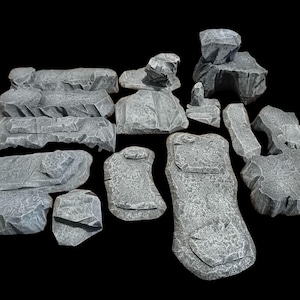 May include: A selection of grey, textured, artificial rocks in diverse shapes and sizes. These rocks are designed to mimic natural stone formations, featuring rough surfaces and irregular edges. Suitable for tabletop gaming or miniature scenery.
