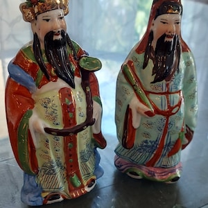 Set of two hand painted Asian porcelain figurines representing prosperity and good fortune.