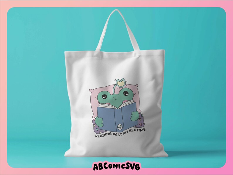 Op de afbeelding: Witte tote bag met een groene kikker die in bed een blauw boek leest. De tekst op de tas is "Reading past my bedtime".