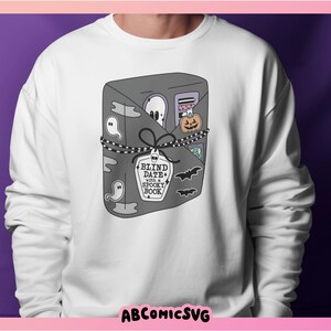 May include: White sweatshirt with a graphic of a closed book with the text "Blind Date with a Spooky Book" on the front.