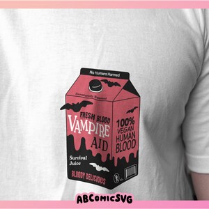 May include: A pink and black carton with the words "Fresh Blood Vampire Aid" and "100% Vegan Human Blood" printed on it. The carton has a black bat design and the words "Survival Juice" and "Bloody Delicious" printed on it.