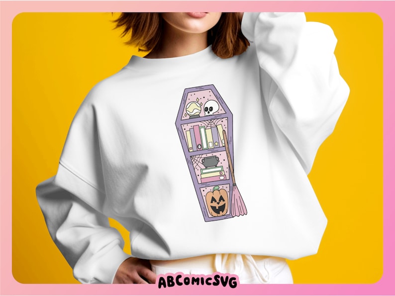 May include: A white sweatshirt featuring a purple coffin-shaped bookshelf design. The bookshelf is filled with books, a cauldron, a broom, a skull, a spiderweb, and a jack-o'-lantern.