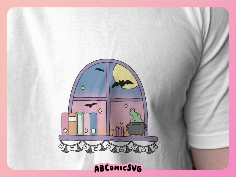 May include: White t-shirt with a cartoon window design. The illustration shows a moon, bats, books, and a cauldron with green potion. The text "ABCOMICSVG" is at the bottom of the design.