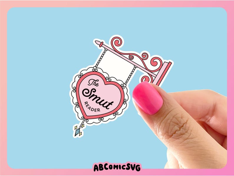 May include: A pink heart-shaped sign with the text "The Smut Reader" hanging from a decorative metal frame. The sign is on a light blue background.