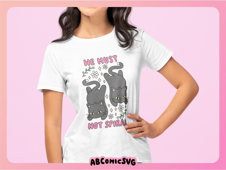 May include: White t-shirt featuring a cartoon design of two gray cats with yellow eyes, surrounded by flowers. The text "HE MUST NOT SPIRAL" is above the cats. The brand name "ABCOMICSVG" is at the bottom.