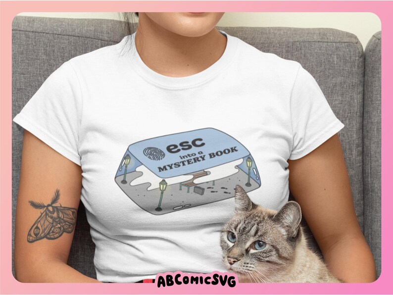 May include: White t-shirt with a blue and white illustration of a book with the text "esc into a mystery book".
