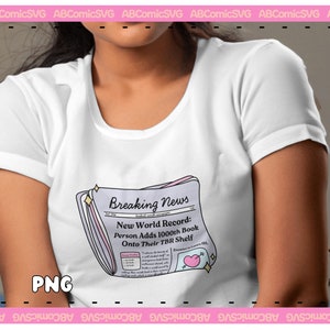 Puede incluir: Una camiseta blanca con un gr&aacute;fico de un titular de peri&oacute;dico que dice "Breaking News: New World Record: Person Adds 1000th Book Onto Their TBR Shelf".