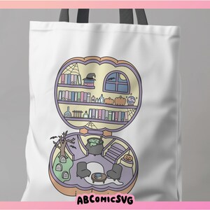 Może przedstawiać: Biała torba z motywem Halloween. Projekt przedstawia dom w kształcie dyni z kapeluszem czarownicy, książkami, dyniami i kotłem. Tekst "ABCOMICSVG" znajduje się na dole.