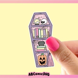 May include: A purple coffin-shaped bookshelf with a skull, a cauldron, books, a crystal ball, and a pumpkin on the shelves. The bookshelf has a spiderweb design and a pink background.