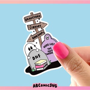 May include: A sticker featuring a graveyard scene with tombstones, ghosts, and a signpost pointing to a graveyard, library, and bookshop. The text on the tombstones reads "DNF" and "HERE LIES THE MAIN CHARACTER". The sticker has a light blue background.