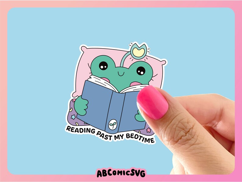 Op de afbeelding: Een groene kikker die een roze kussen en een lichtblauw boek met een groen blaadjesontwerp draagt. De kikker leest het boek en de tekst zegt "Reading past my bedtime".