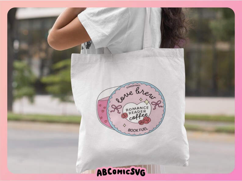 Puede incluir: Bolso de mano blanco con un gr&aacute;fico circular con las palabras "Love Brew" y "Romance Reader Coffee". El dise&ntilde;o incluye una taza de caf&eacute; rosa, corazones y rosas. Tambi&eacute;n est&aacute; presente el texto "Book Fuel". La bolsa tiene el texto "ABCOMICSVG" en la parte inferior.
