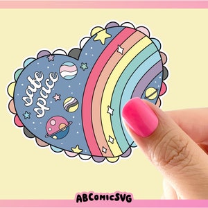 May include: A blue heart-shaped sticker with a rainbow, stars, and planets. The text "safe space" is written in white on the sticker.