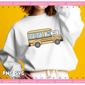 Pode incluir: Uma camisa de moletom branca com um gr&aacute;fico de &ocirc;nibus escolar amarelo. O &ocirc;nibus tem um ganso dirigindo e um bal&atilde;o de fala que diz "Entre, bestie!" O &ocirc;nibus &eacute; rotulado como "Struggle Bus".