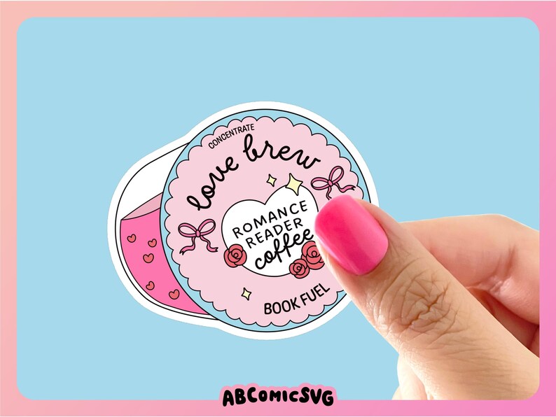 Puede incluir: Una pegatina con un dise&ntilde;o rosa y blanco, con las palabras "love brew" y "Romance Reader Coffee". La pegatina tiene un fondo azul claro e incluye lazos, corazones y rosas. Tambi&eacute;n est&aacute; presente el texto "Book Fuel". La imagen est&aacute; sostenida por una mano con esmalte de u&ntilde;as rosa.