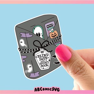 May include: A black and white sticker with a spooky book theme. The sticker says "Blind Date with a Spooky Book".