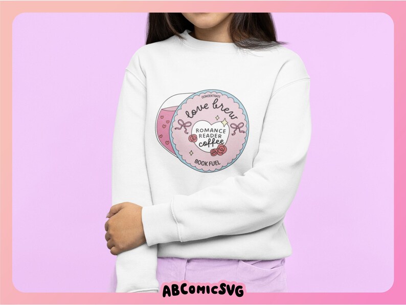 Puede incluir: Sudadera blanca con un gr&aacute;fico. El gr&aacute;fico incluye una taza de caf&eacute; rosa y un dise&ntilde;o circular con el texto "love brew", "Romance Reader Coffee" y "Book Fuel". El dise&ntilde;o incluye corazones, rosas y lazos.