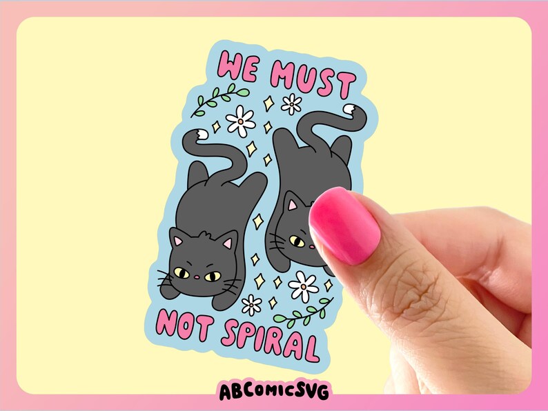 May include: A sticker featuring two gray cartoon cats, one upright and one upside down, on a light blue background. The sticker has the text "WE MUST NOT SPIRAL" in pink. White flowers and green vines decorate the background. The sticker is held by a hand with pink nail polish.
