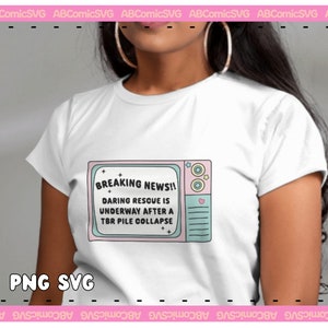 May include: A white t-shirt with a graphic of a vintage television screen with the text "BREAKING NEWS!! DARING RESCUE IS UNDERWAY AFTER A TBR PILE COLLAPSE".