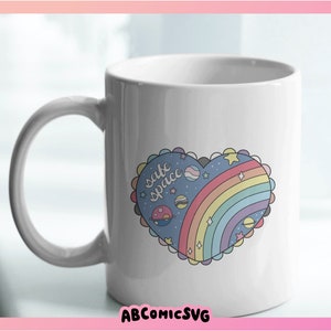 May include: White ceramic mug with a rainbow heart design. The heart has a blue background with stars, planets, and the text "cute spice" inside.
