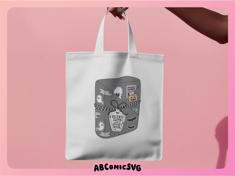 May include: A white tote bag with a gray and black illustration of a book with the text "Blind Date with a Spooky Book" on a tag. The book is filled with spooky Halloween items like ghosts, bats, and a pumpkin.