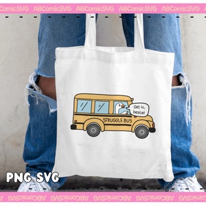 Pode incluir: Uma bolsa tote branca com uma ilustra&ccedil;&atilde;o de um &ocirc;nibus escolar amarelo e um ganso dirigindo. O &ocirc;nibus diz "STRUGGLE BUS" e "Get in, bestiel".