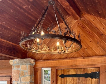 May include: A large, round, wrought iron chandelier with a pine cone and branch design. The chandelier has four lights and is hanging from a wooden ceiling.