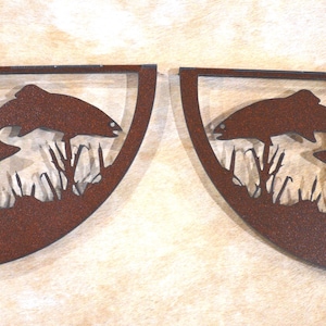 May include: Two rusty brown metal corner shelf brackets with a cutout design of a fish jumping out of the water with reeds.