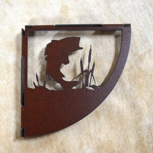 May include: A rusty brown metal corner shelf with a cutout design of a bass fish jumping out of the water with reeds in the background.