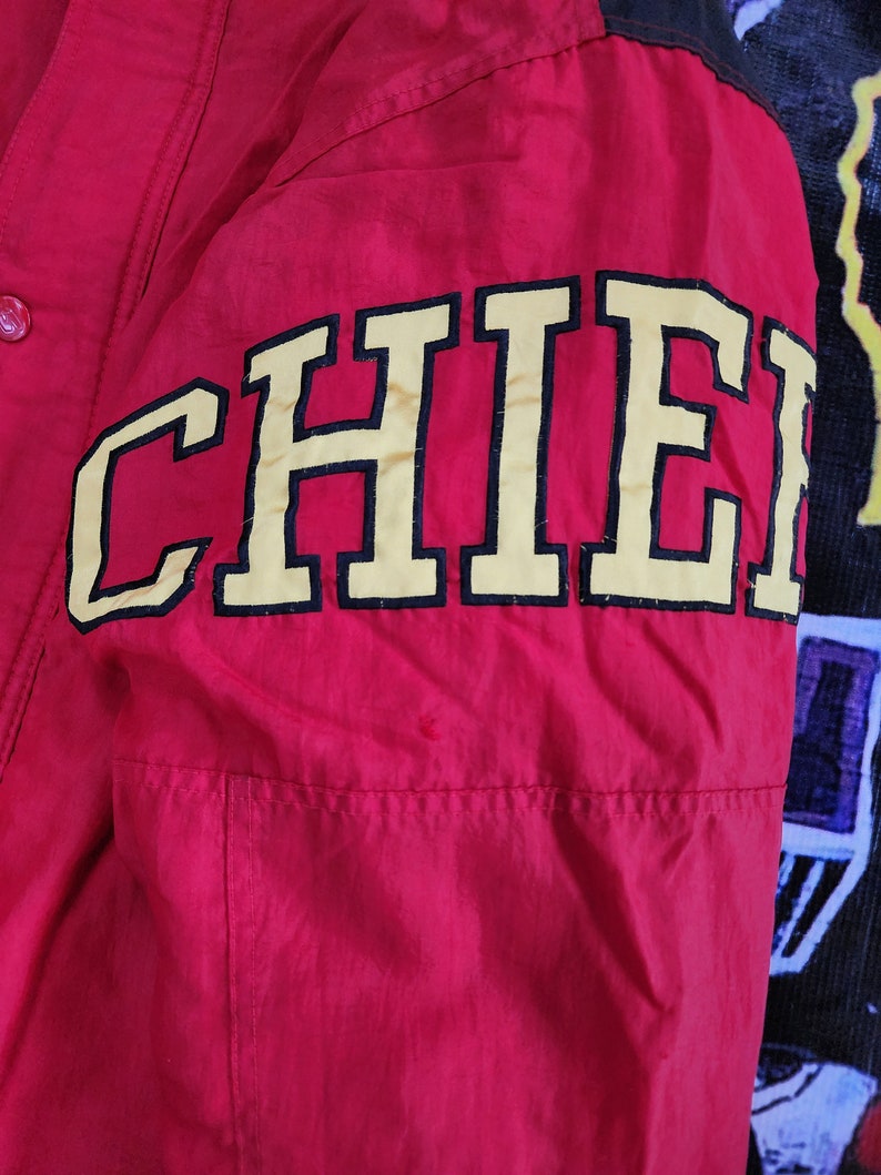 May include: Red jacket with a black and yellow "CHIEFS" embroidered on the sleeve.