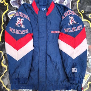 May include: A navy blue Arizona Wildcats Starter jacket with red and white accents. The jacket features the team name and logo on the sleeves and chest. The jacket has a full zip closure and a stand-up collar.