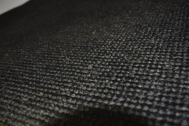 Peut inclure: Gros plan sur un tissu textur&eacute; noir avec un motif en grille. Le tissu a une finition l&eacute;g&egrave;rement brillante.