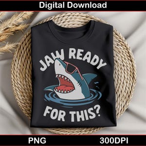 Puede incluir: Camiseta negra con un gráfico blanco de un tiburón con gafas de sol y el texto "JAW READY FOR THIS?"